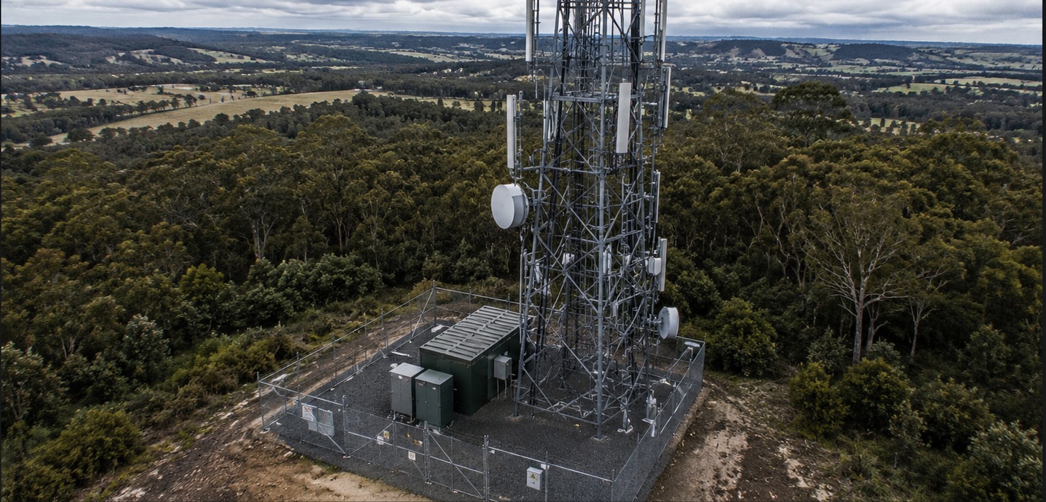 Aerial view of a telecommunications compound with maintained vegetation and shelter